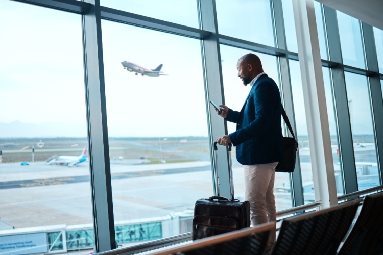 a business man checks his phone in an airport